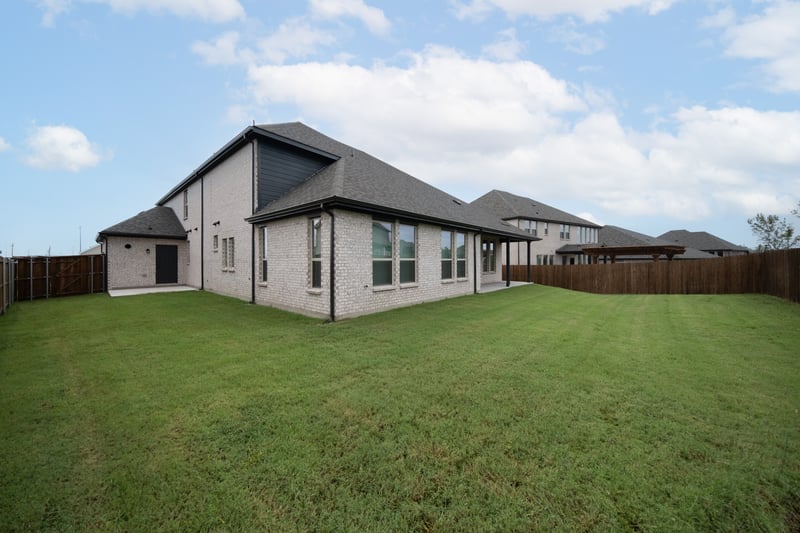 backyard of home with covered patio and access from third-car garage