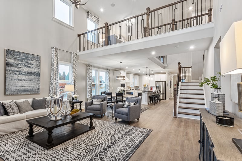 great room with two story ceiling, sofa, area rug, and view of the kitchen