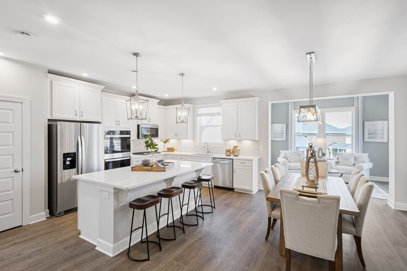 kitchen area with hardwood floors, all-white cabinetry, plus four barstools at the island