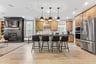 kitchen area with hardwood floors, a large island, and four black barstools