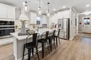 kitchen with white cabinets, white countertops, and black bar stools