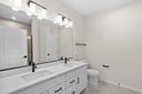 primary bathroom dual sinks and white cabinets