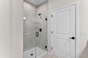 primary bathroom with shower with black hardware and tile