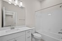 secondary bathroom with sink, tub, shower and mirror