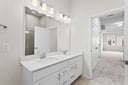 primary bathroom with two sinks and white cabinets