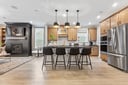 kitchen area with hardwood floors, a large island, and four black barstools