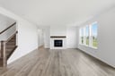 great room with wood plank flooring and a fireplace with shiplap