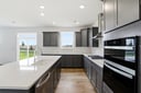 kitchen with dark gray cabinets and a white tile backsplash