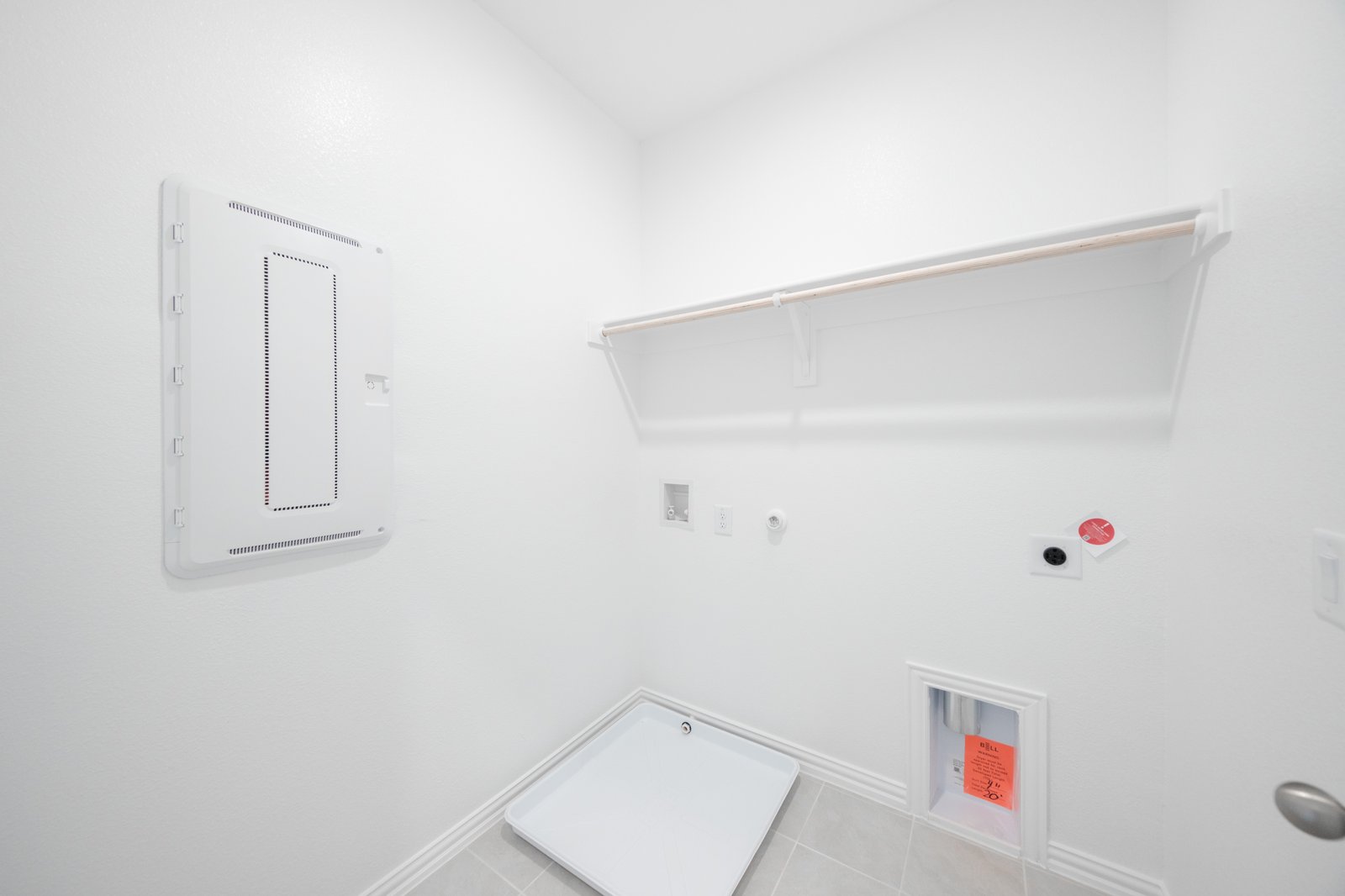 laundry room with tile floors and white shelf