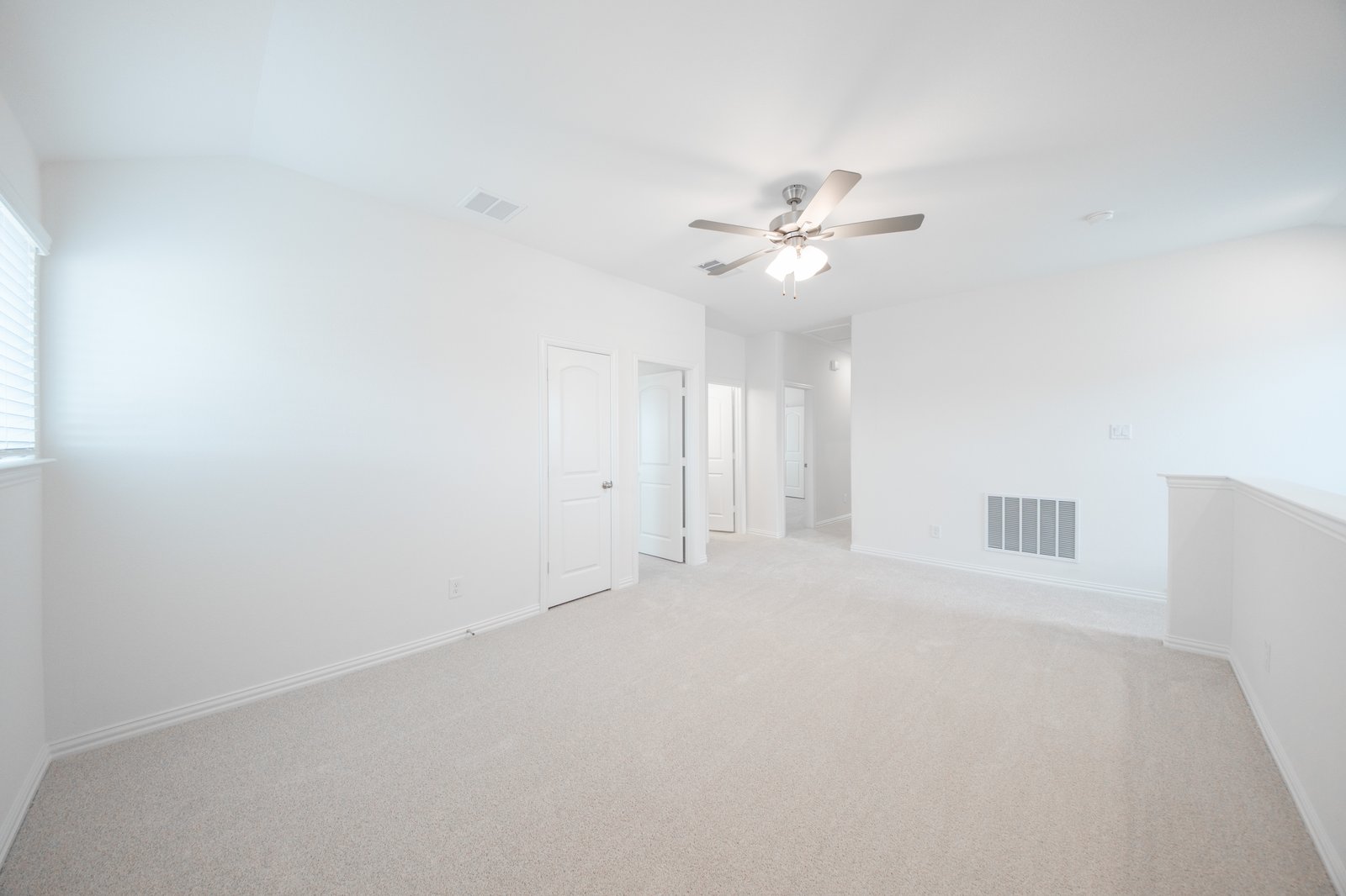 open loft with carpet and ceiling fan