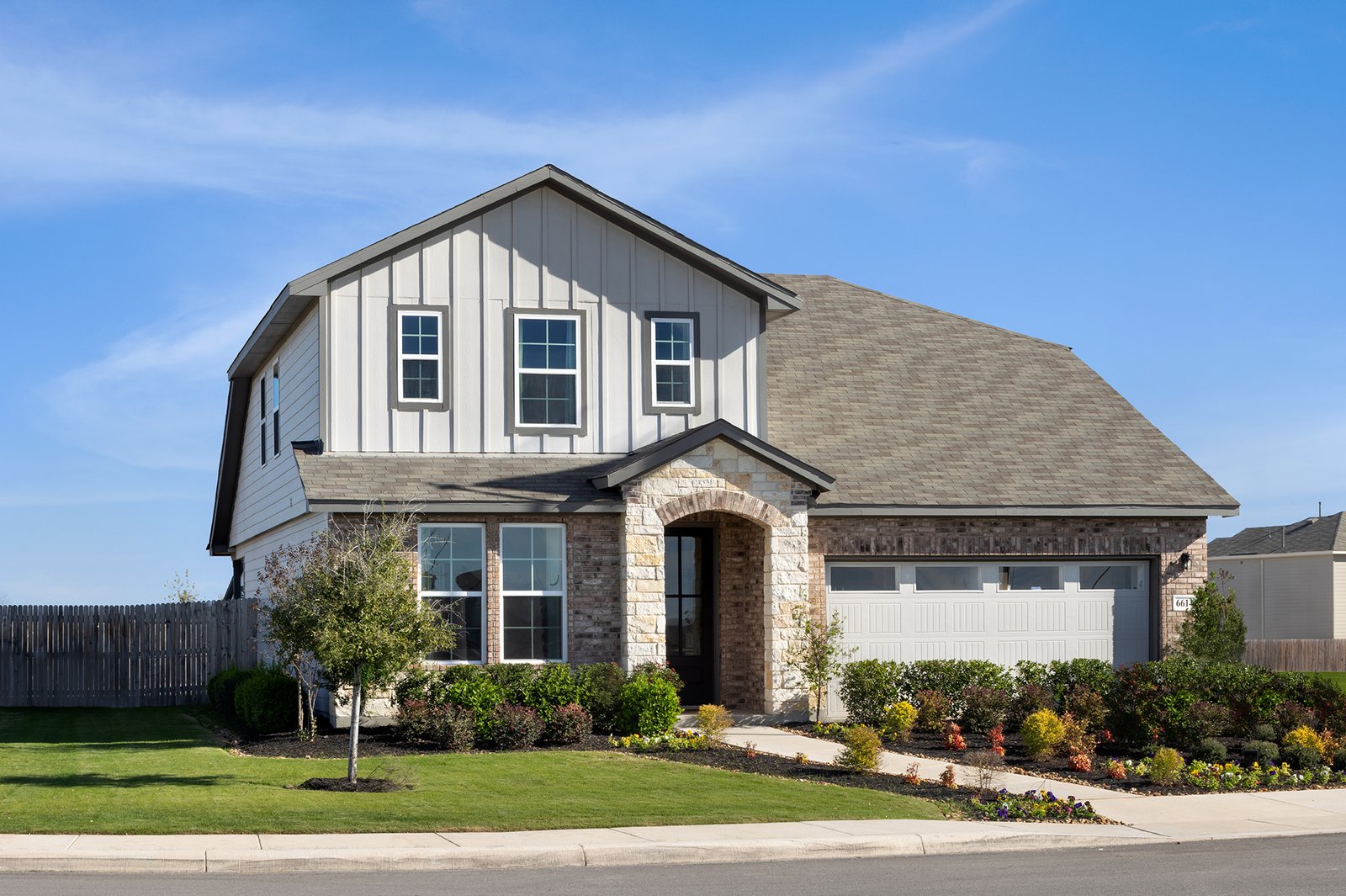 exterior with brick, tree & a 2-car garage