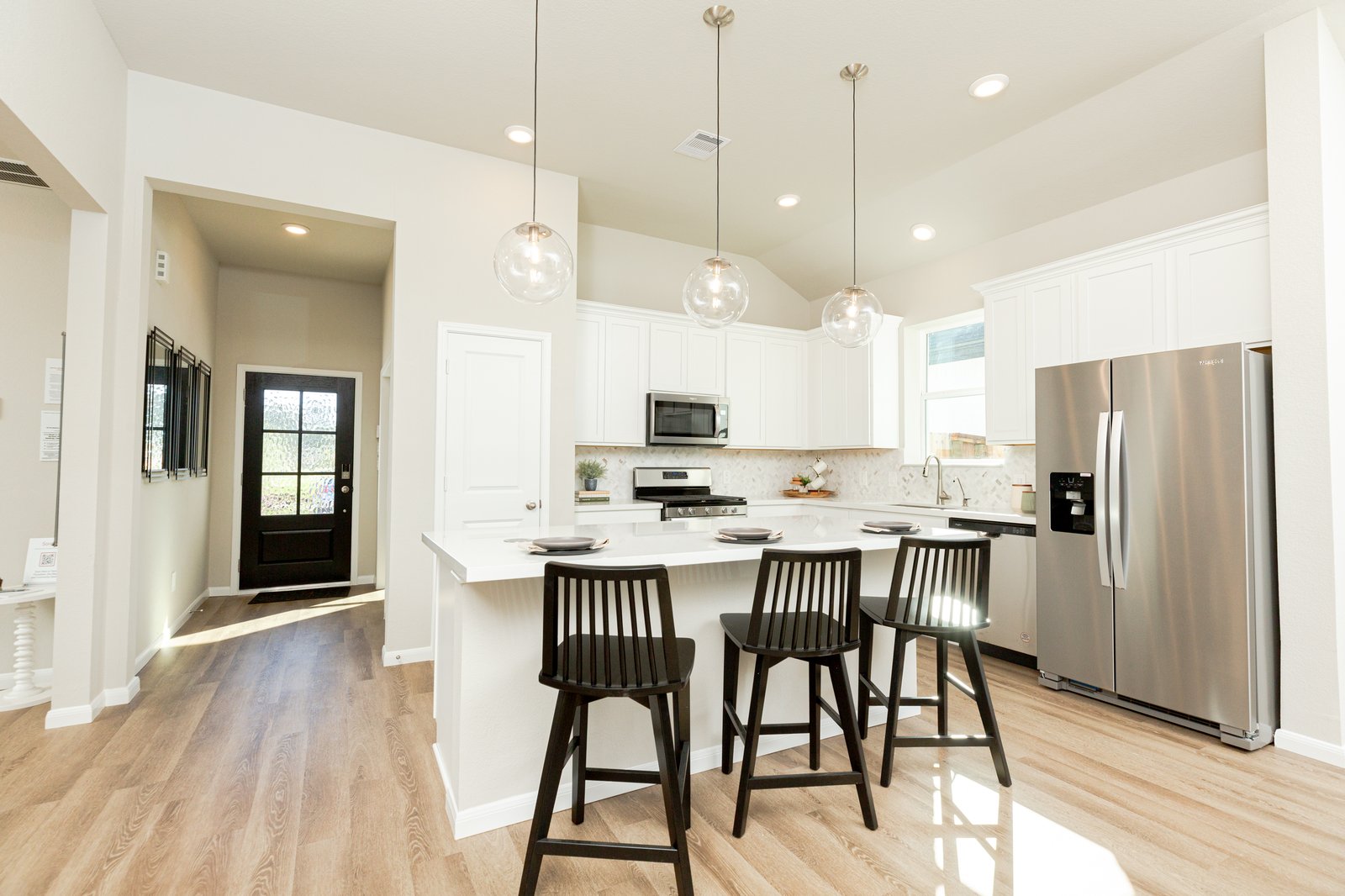 open kitchen with white cabinets and hardwood flooring