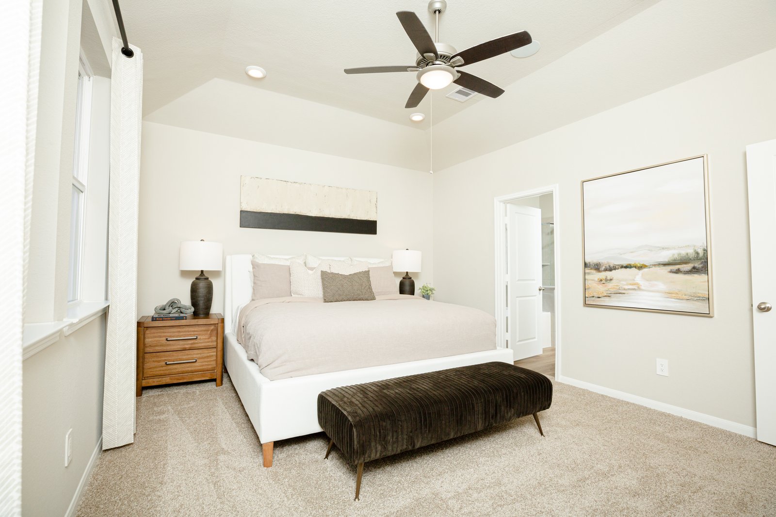 large primary bedroom with carpet and windows