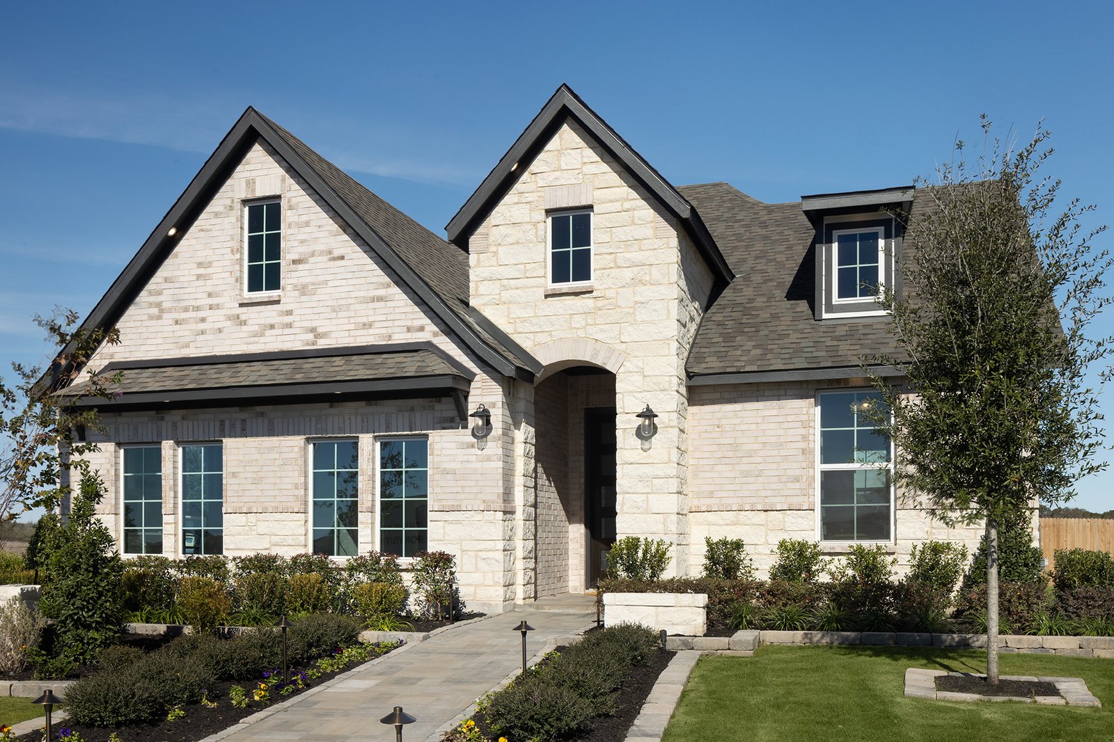 exterior with brick, stone & a covered porch 