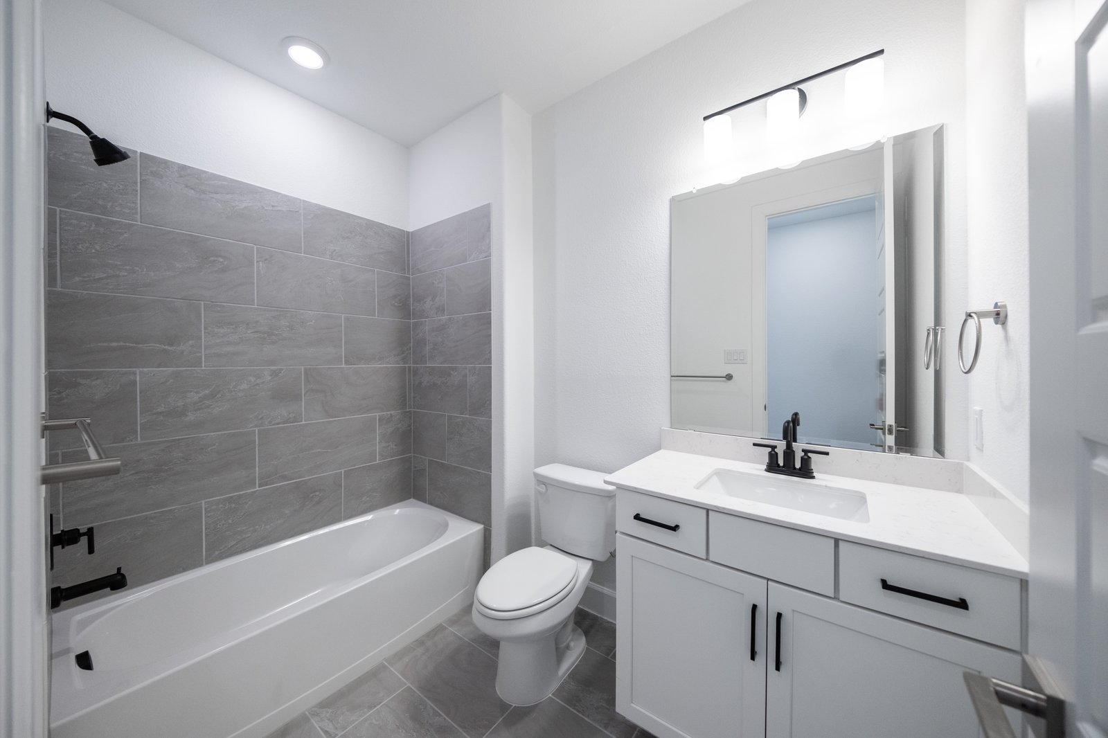 bathroom with tub and white cabinets