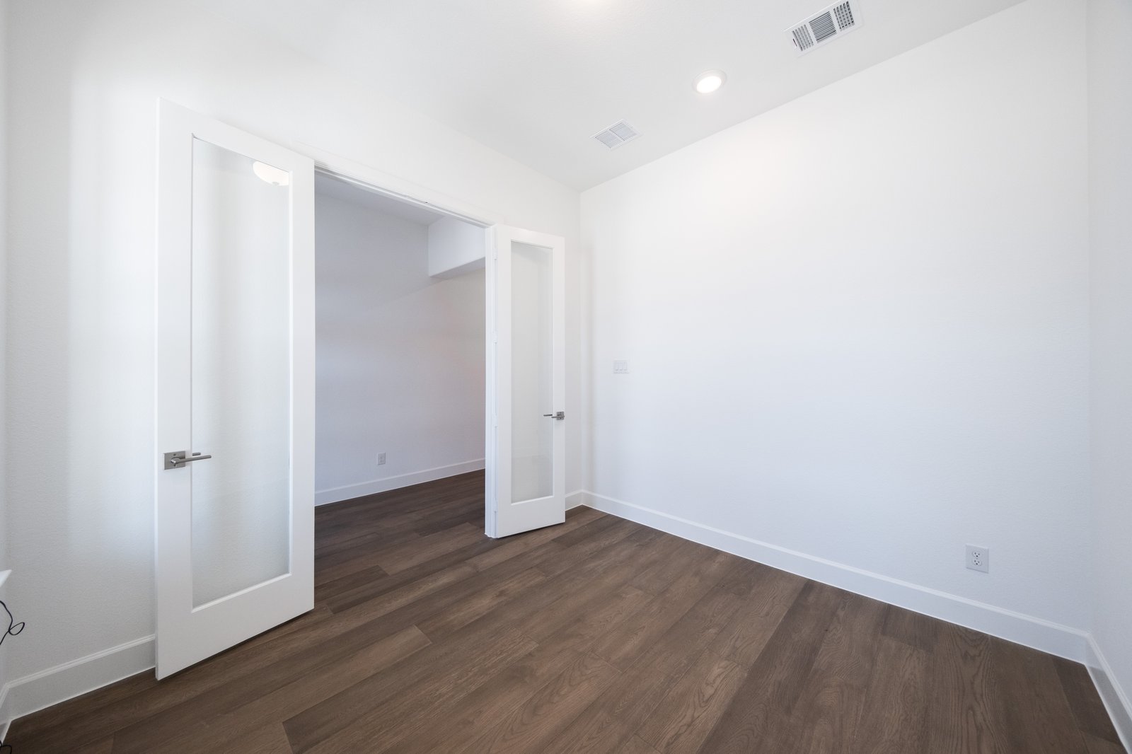 study with wood flooring and french doors