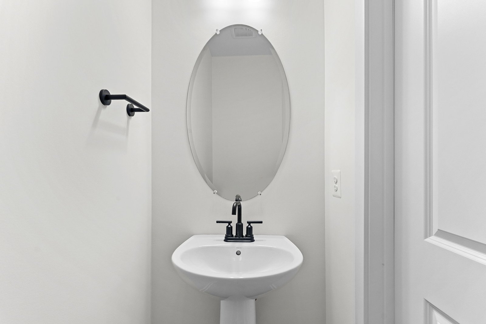 powder room with an oval mirror