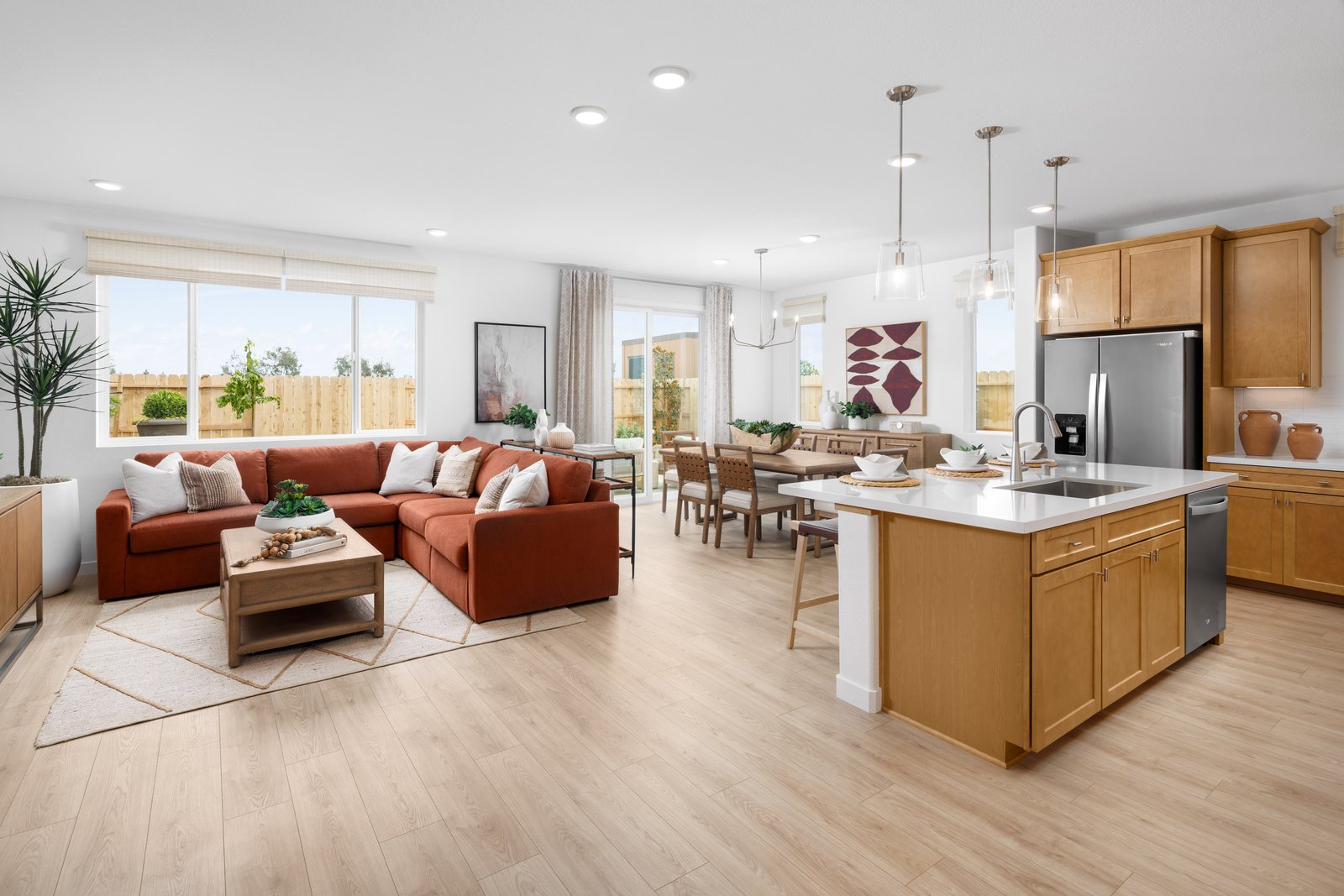 great room with wood floors, rust sectional sofa, wood coffee table, and multiple windows