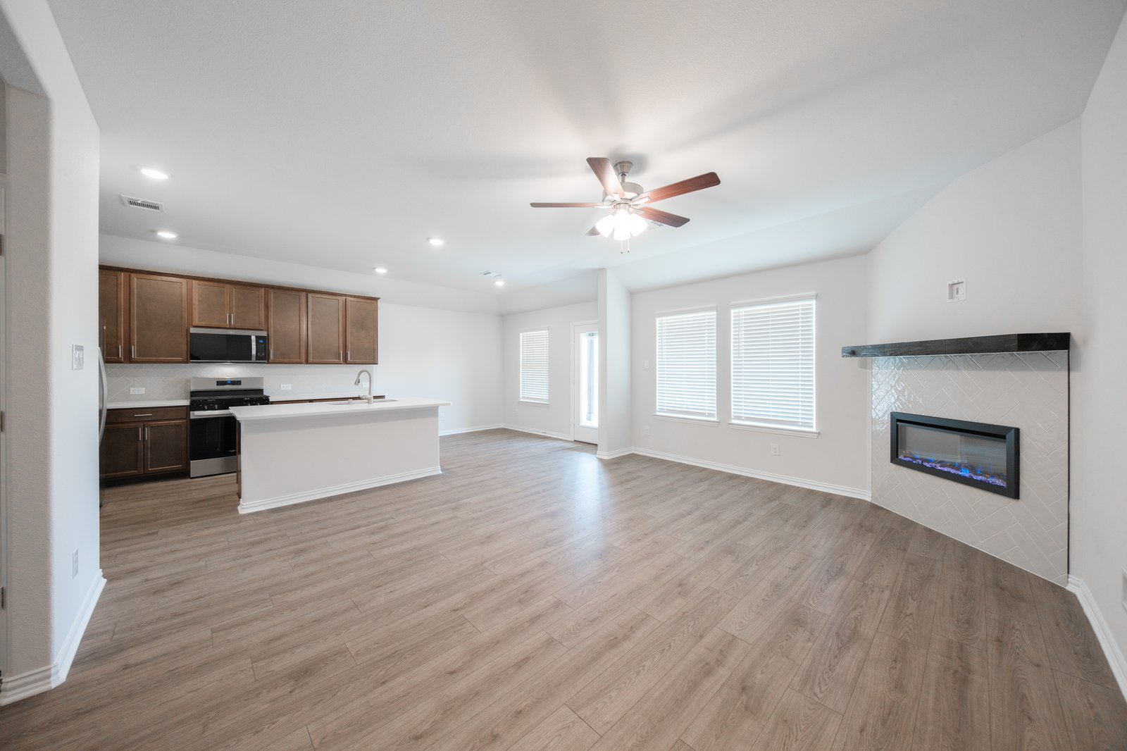 open great room with wood floors and fireplace