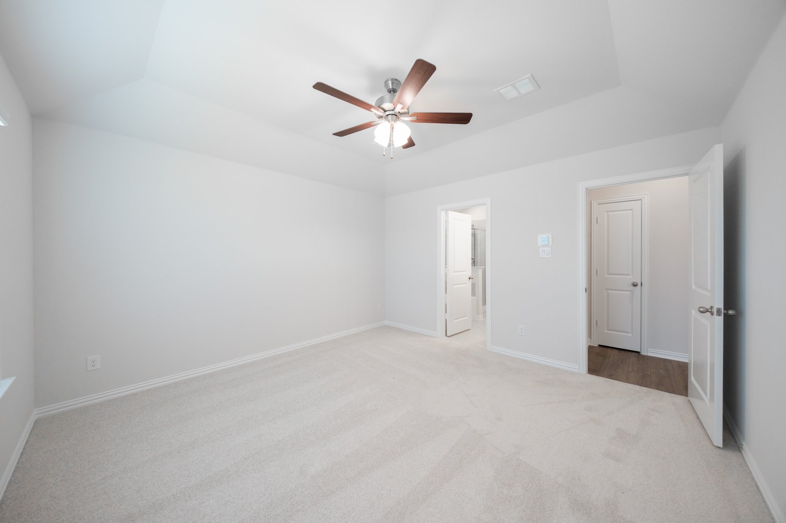 primary bedroom with carpet and ceiling fan