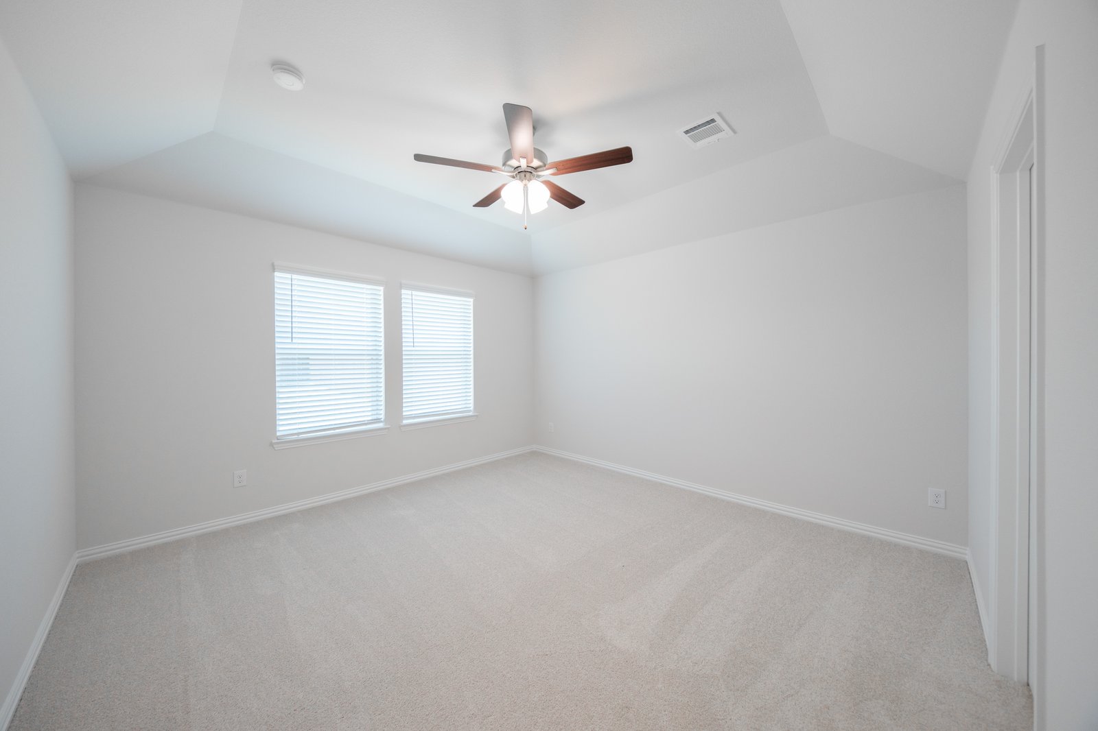primary bedroom with carpet and ceiling fan