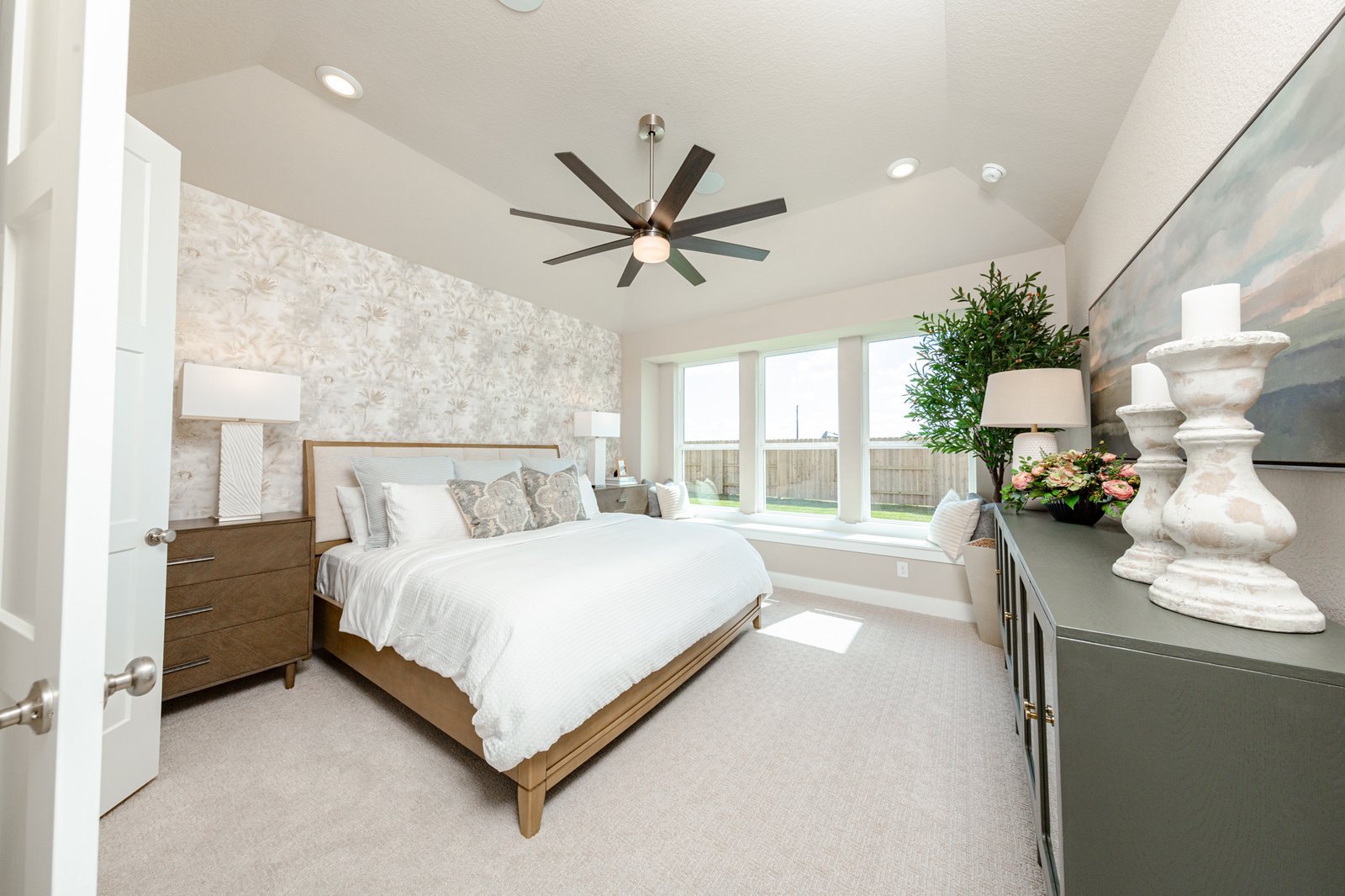 primary bedroom with tall ceilings and windows