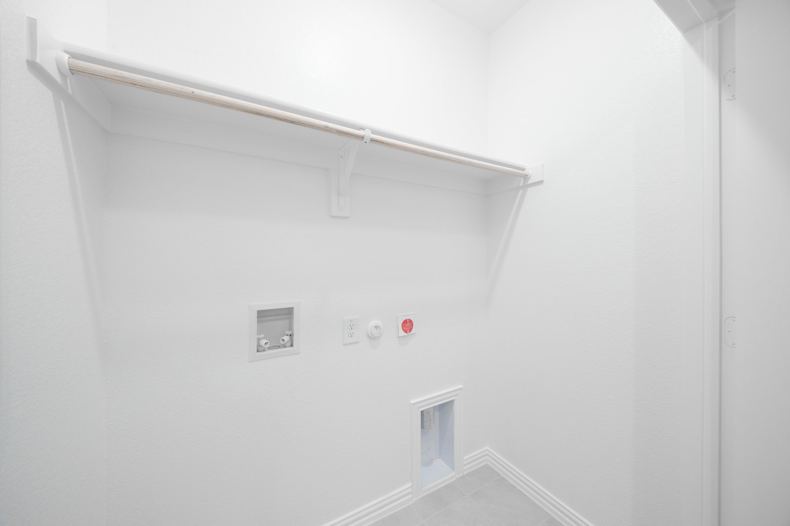 laundry room with tile floors and white shelf