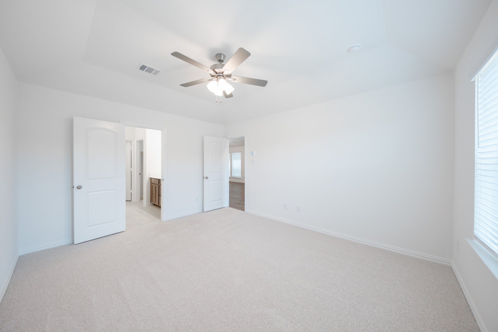 primary bedroom with carpet and ceiling fan