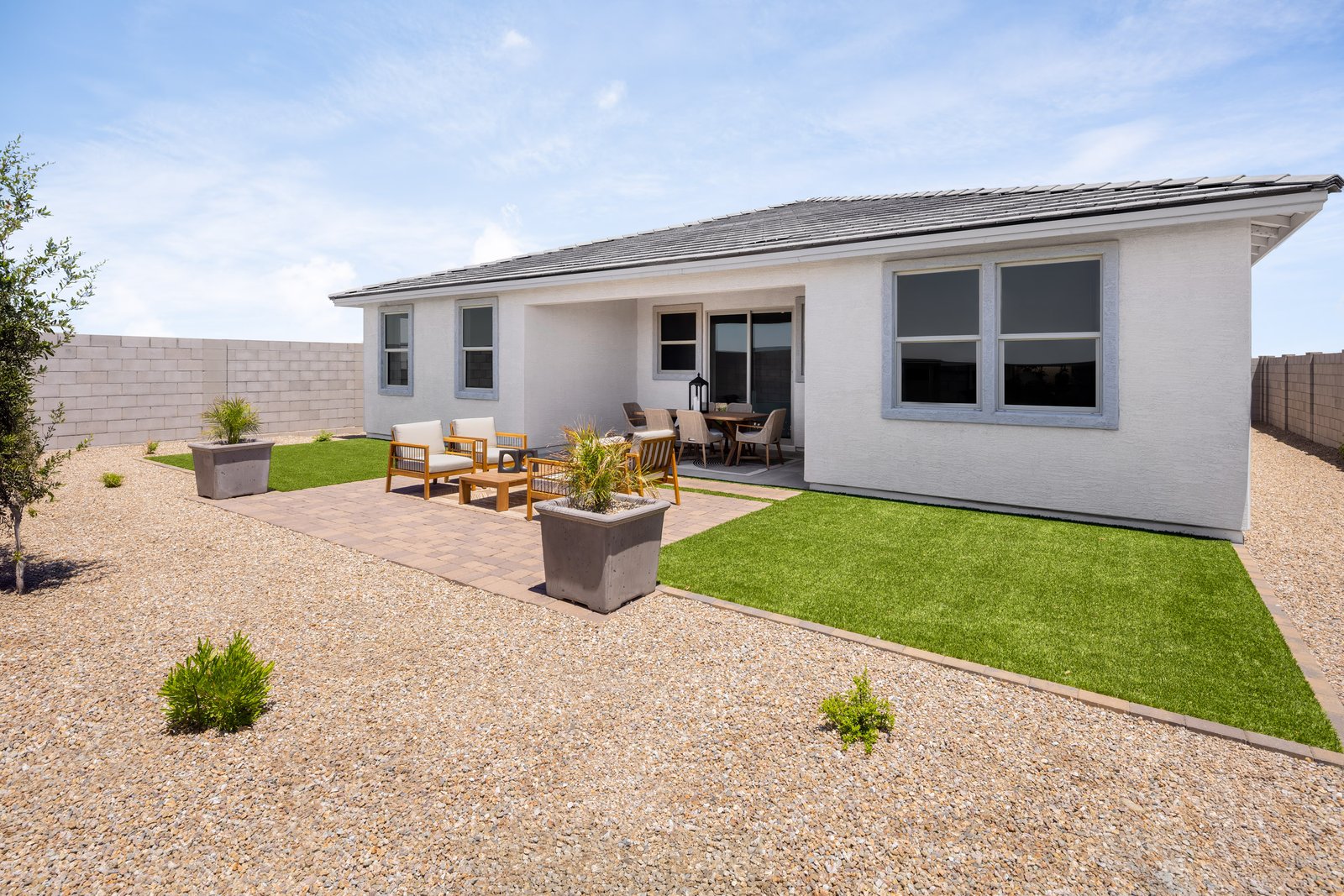spacious backyard with artificial grass and pavers