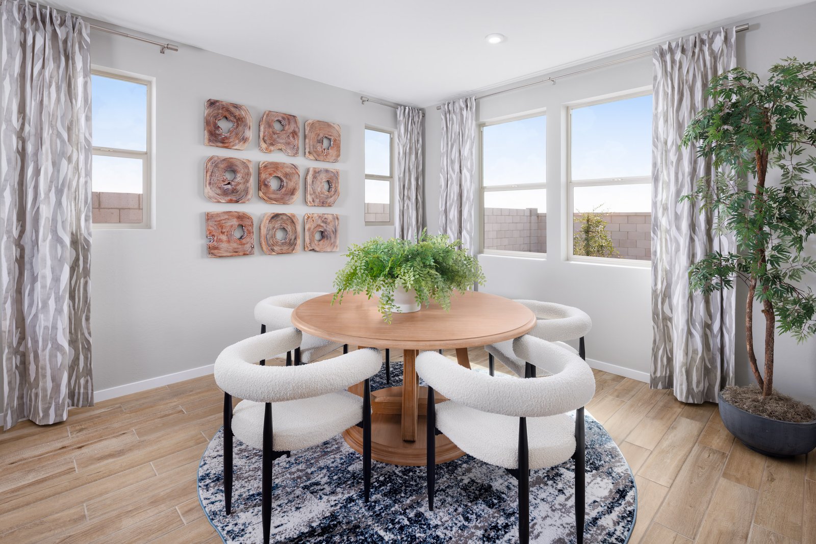open-concept space with wood-like flooring, white dining chairs and wooden table