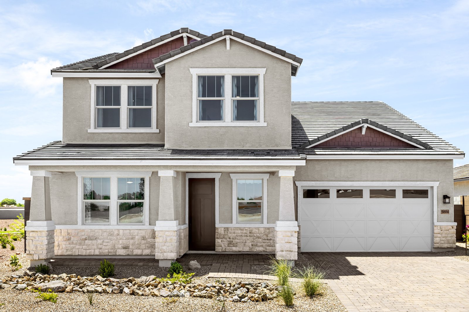 two-story home with desert lanscaping and paver driveway