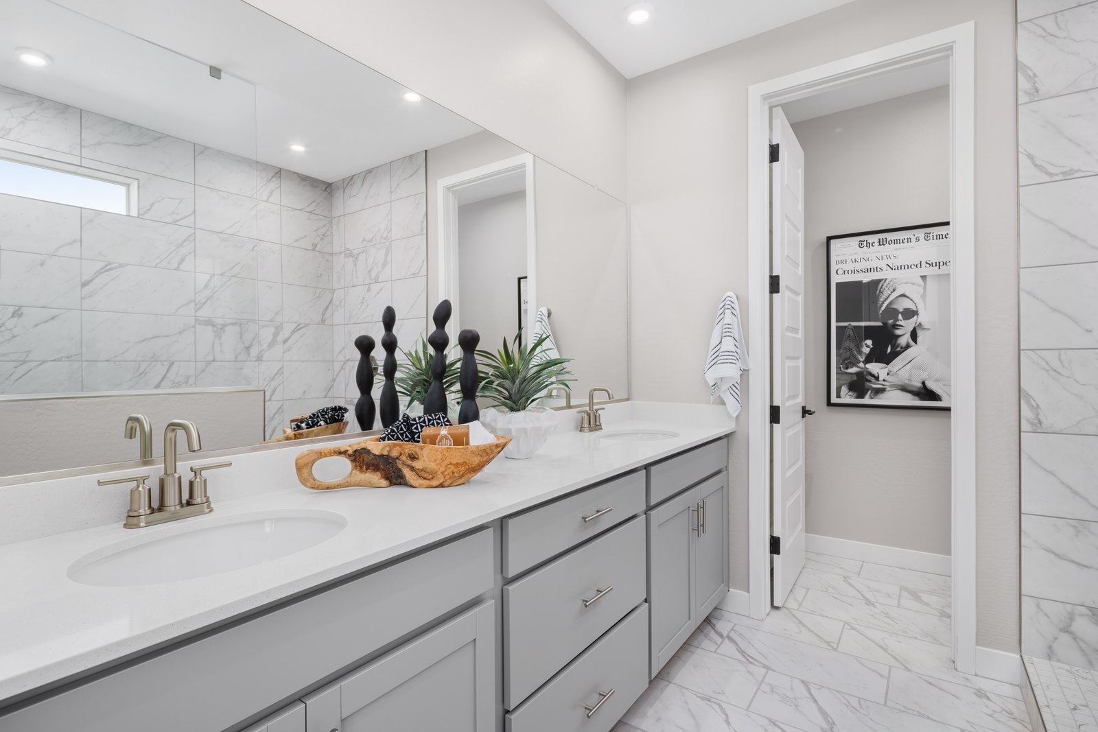 bathroom with marble-like flooring, grey cabinets and brushed nickel hardware