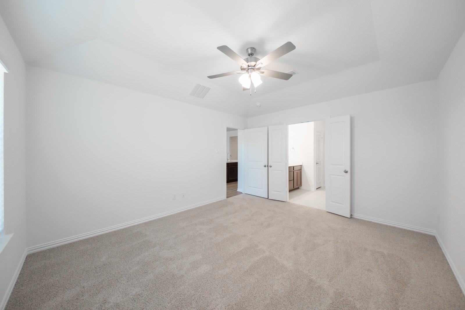 primary bedroom with carpet and ceiling fan