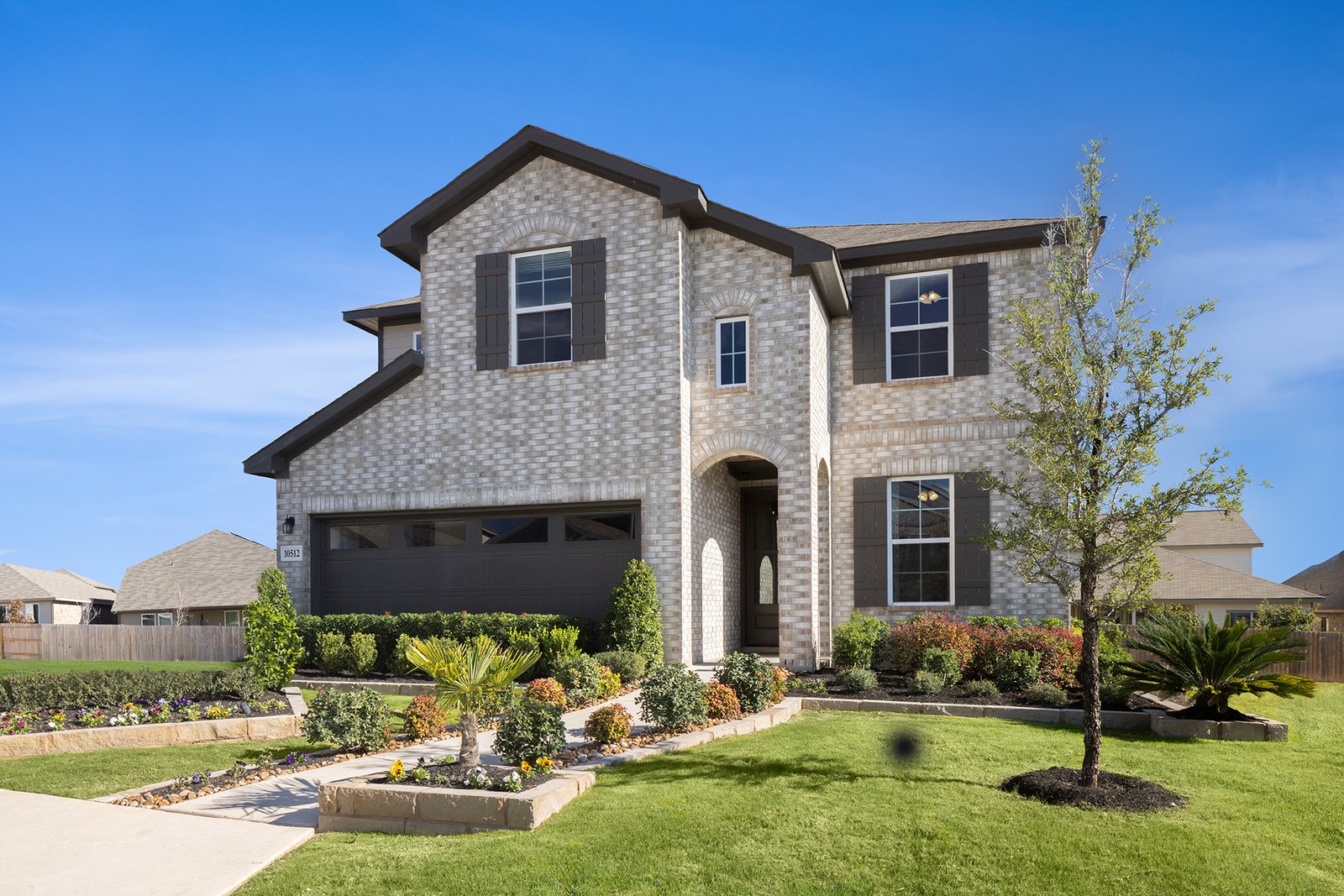 exterior with brick, grass & a 2-car garage