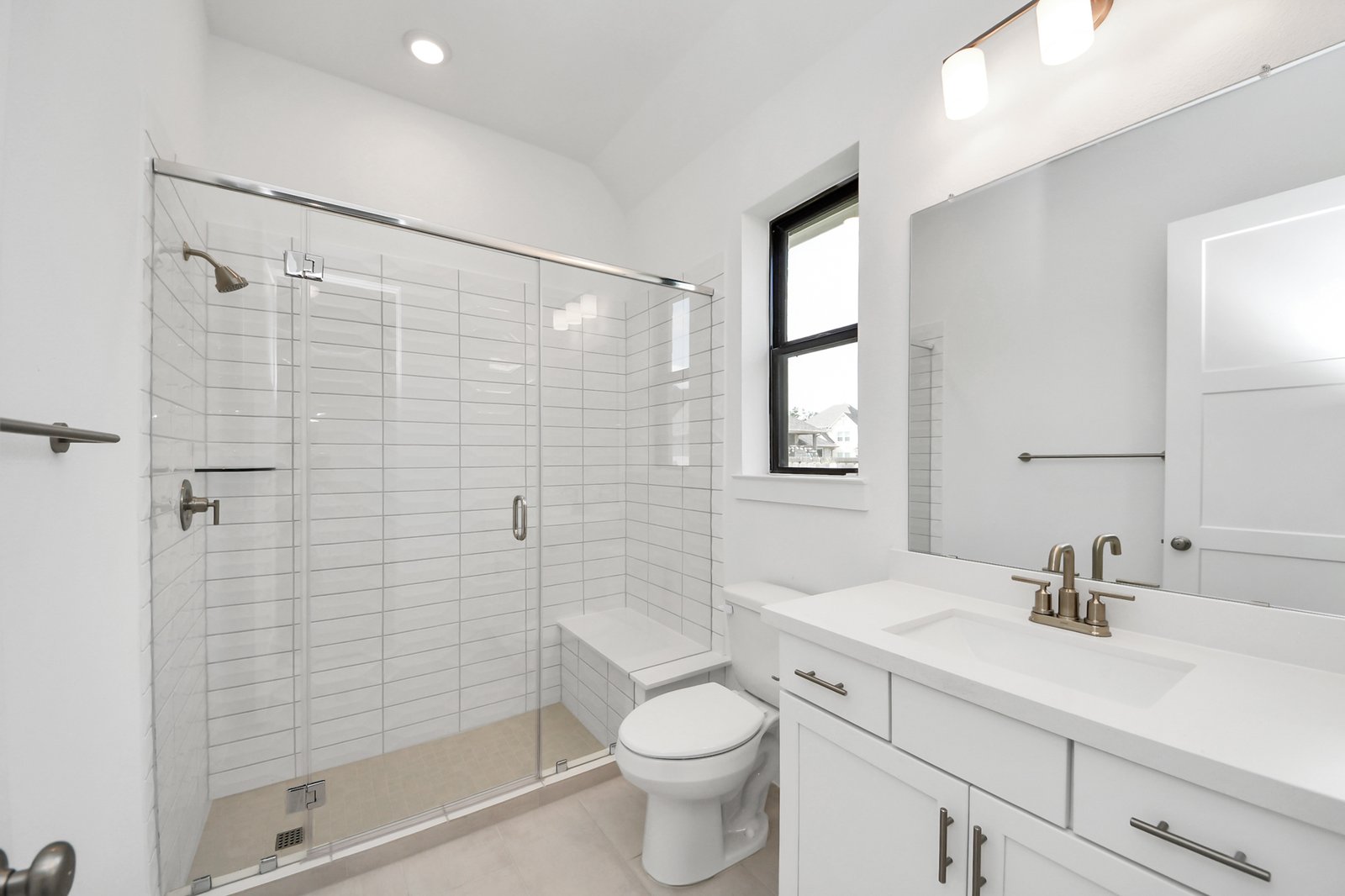 tiled shower and vanity with white cabinets