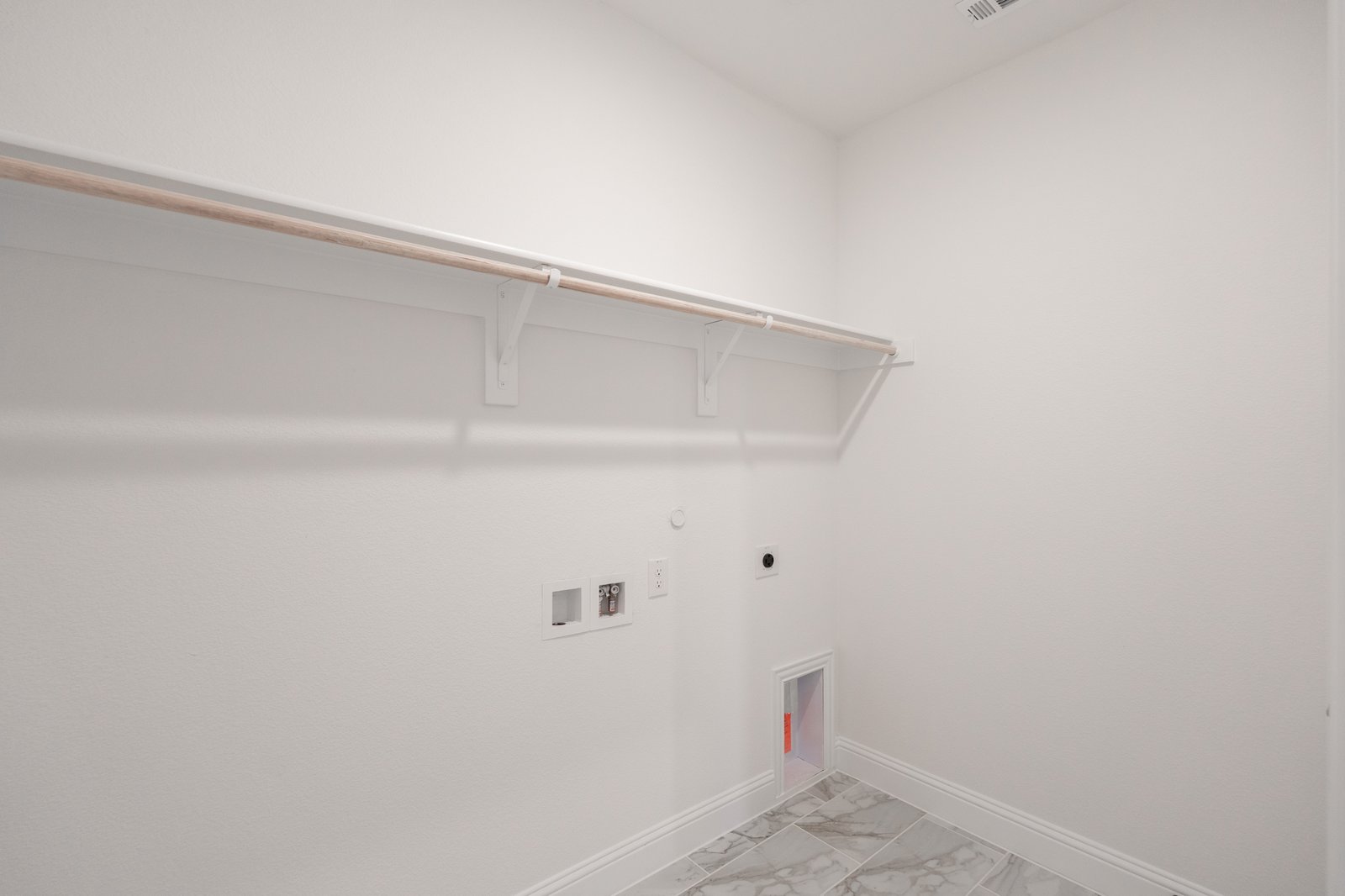 laundry room with tile floors and white shelf