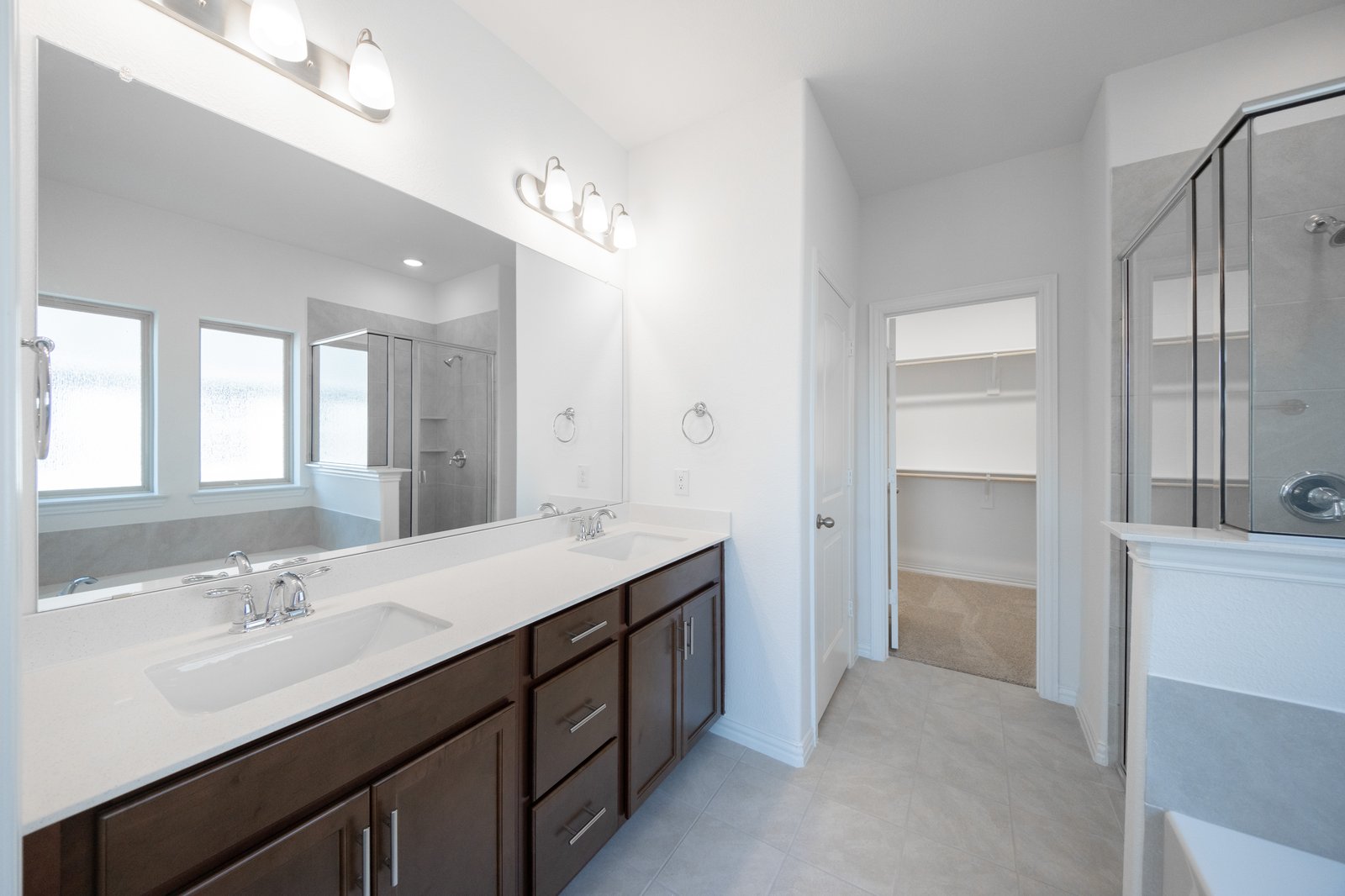 primary bathroom with double sinks and tile flooring