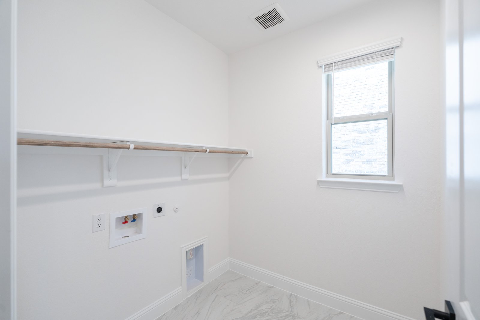 laundry room with tile floors and white shelf