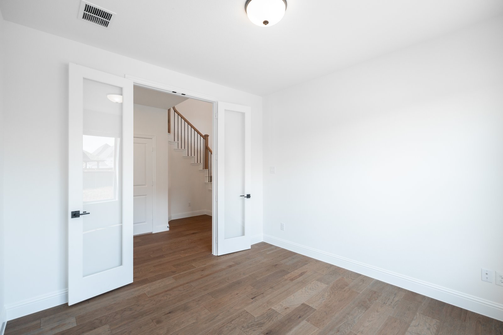private study with wood floors and windows