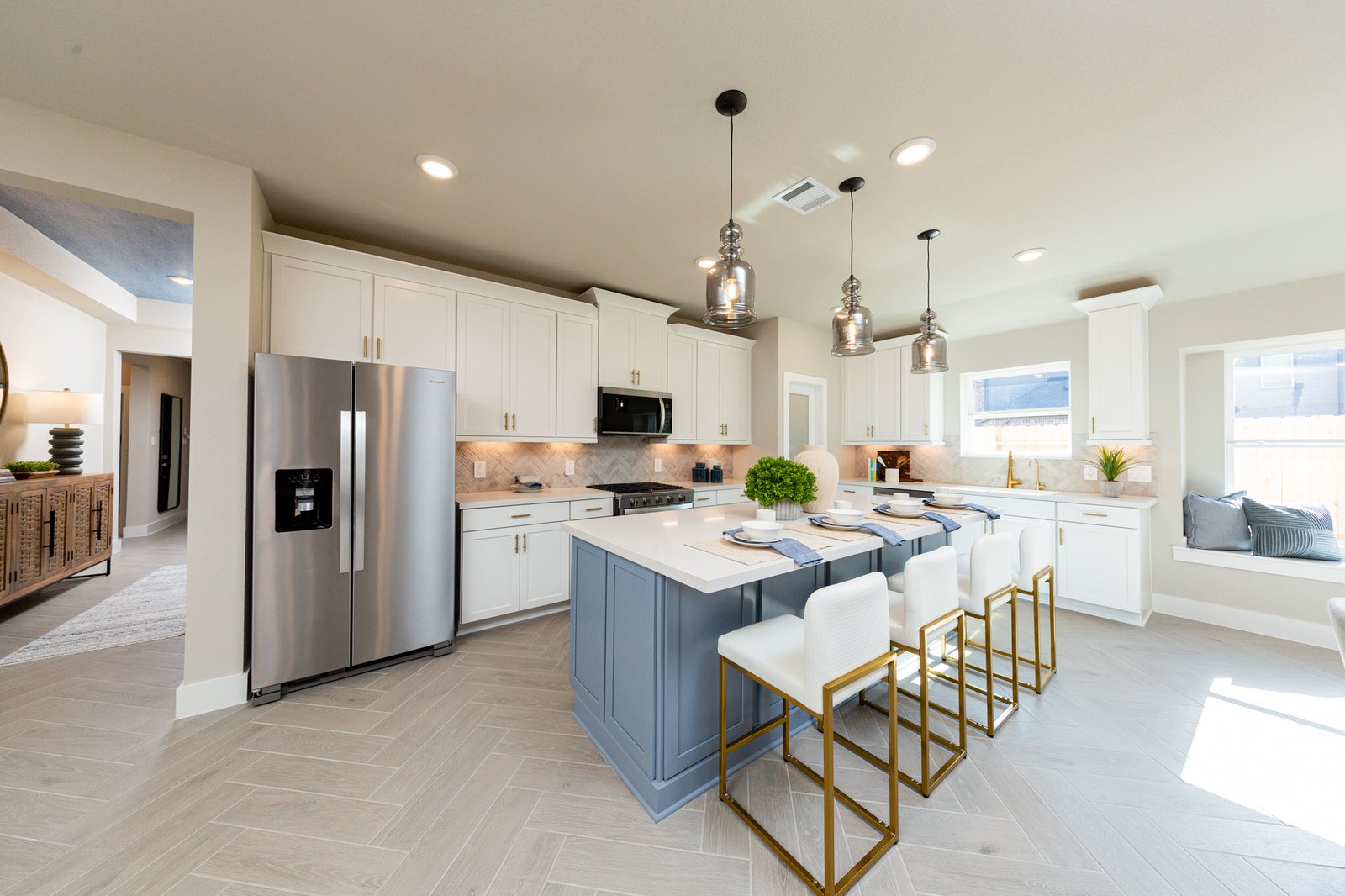 spacious kitchen with white cabinets and herringbone flooring