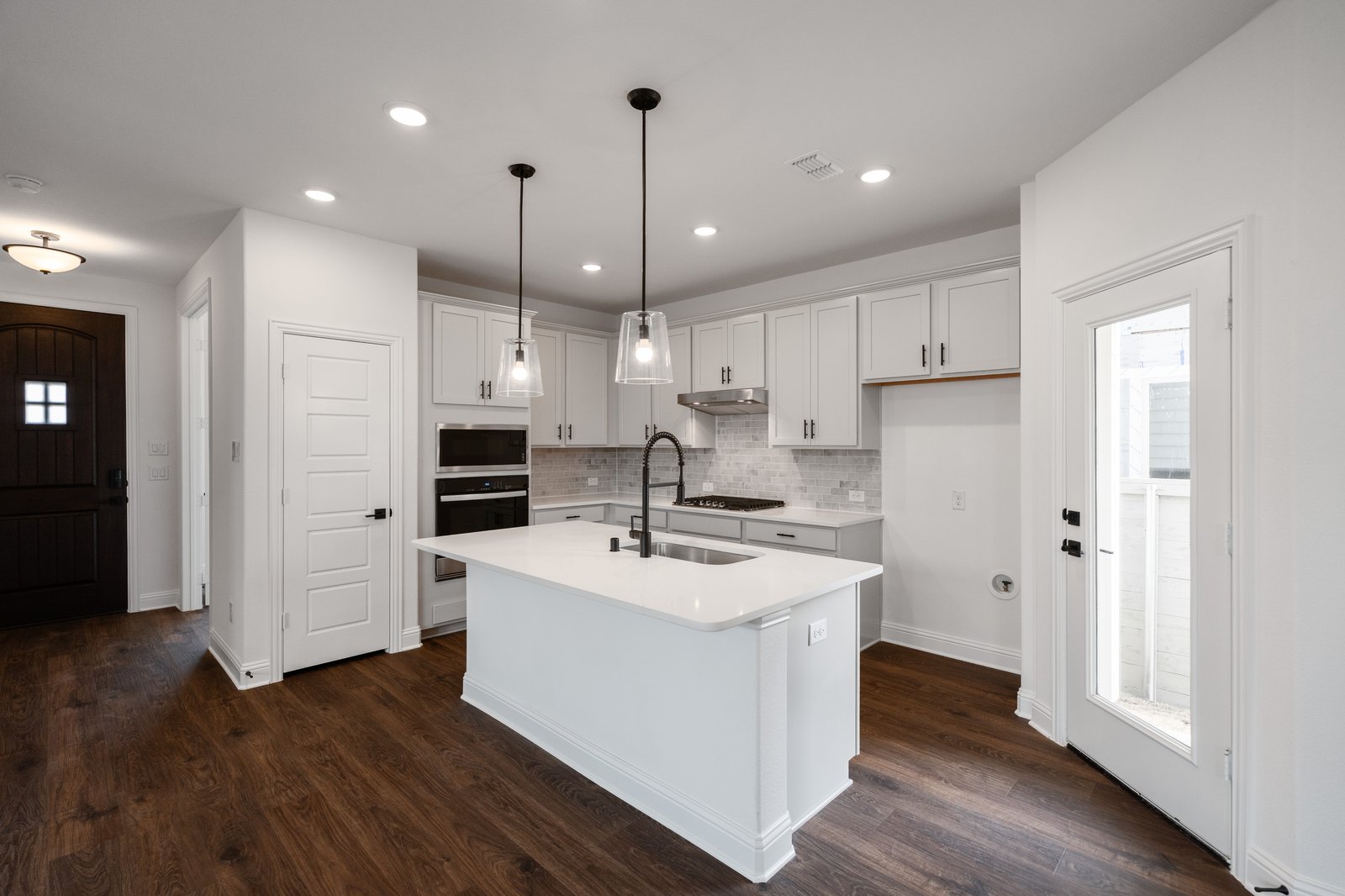 open kitchen with wood floors and white cabinets