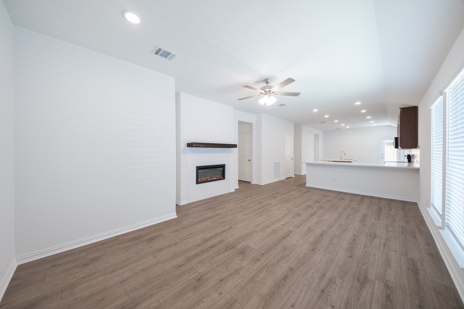 open great room with wood floors and fireplace