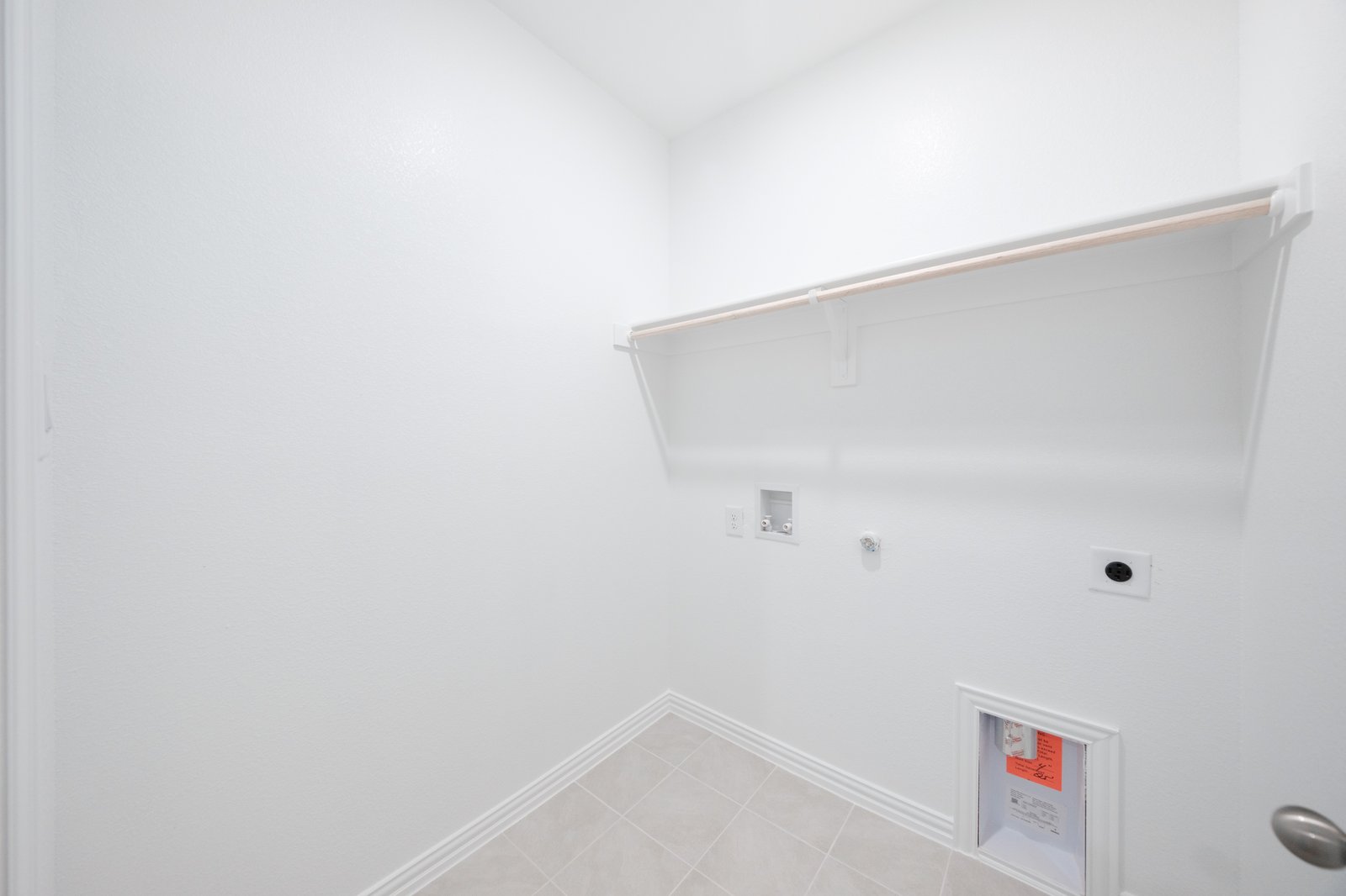 laundry room with tile floors and white shelf