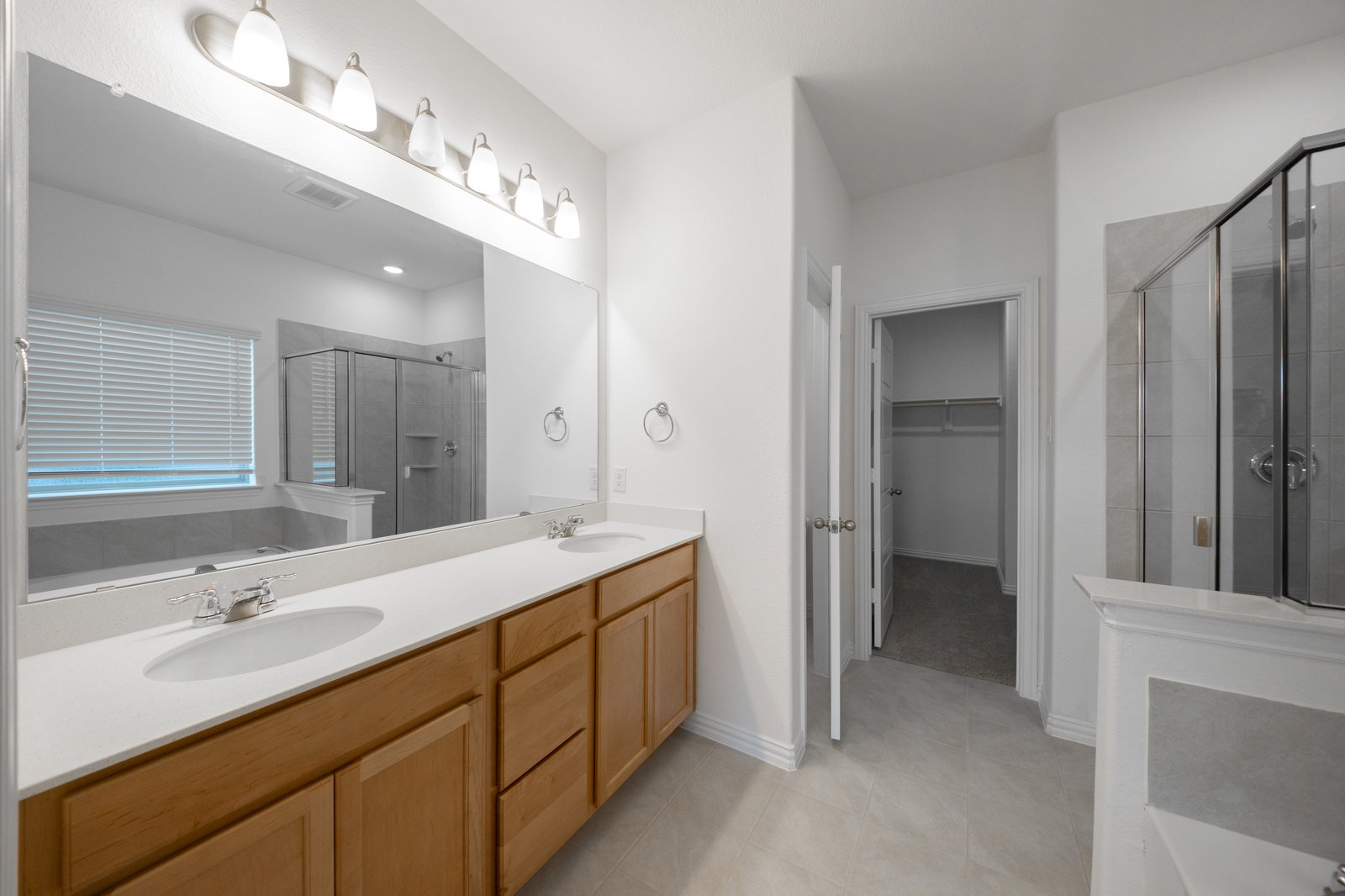 primary bathroom with two sinks and tile floors