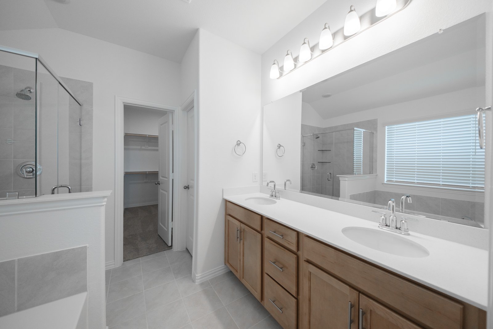 bathroom with brown cabinets and two sinks