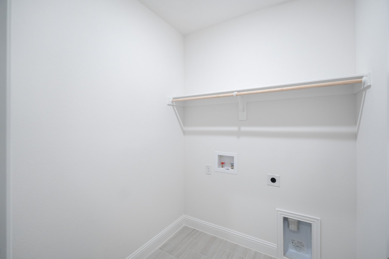 laundry room with tile floors and white shelf