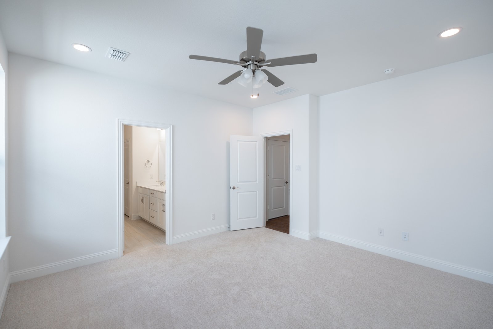 primary bedroom with carpet and ceiling fan