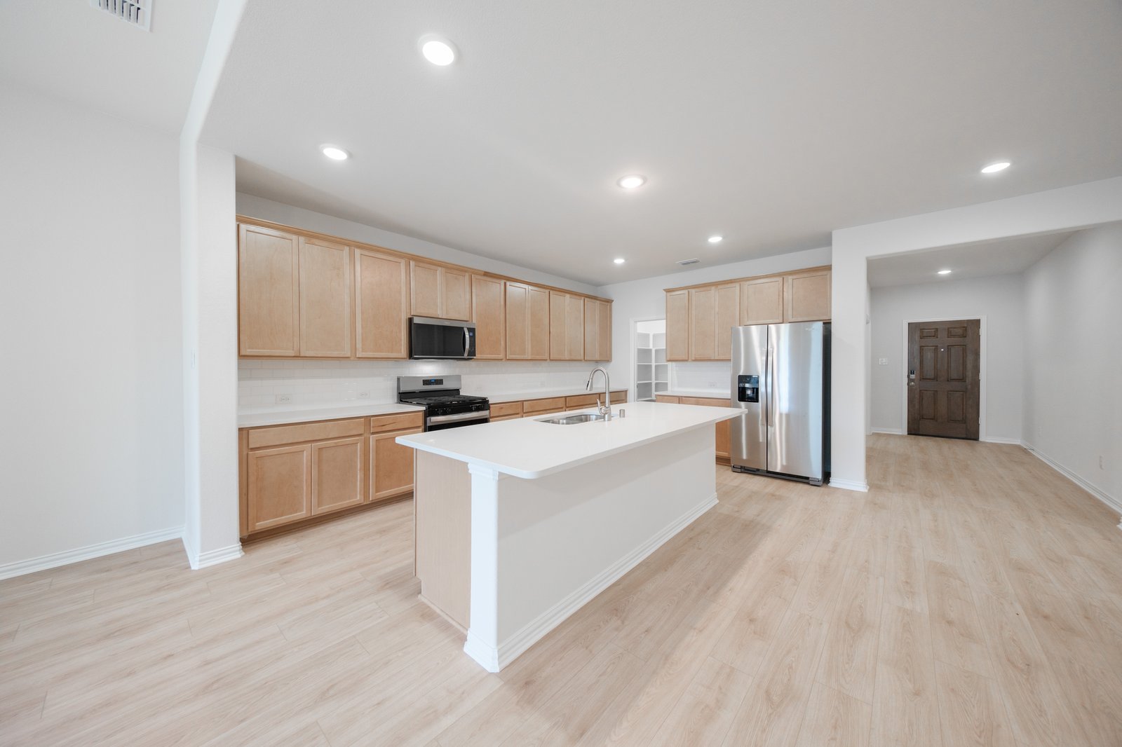 open kitchen with wood floors and island