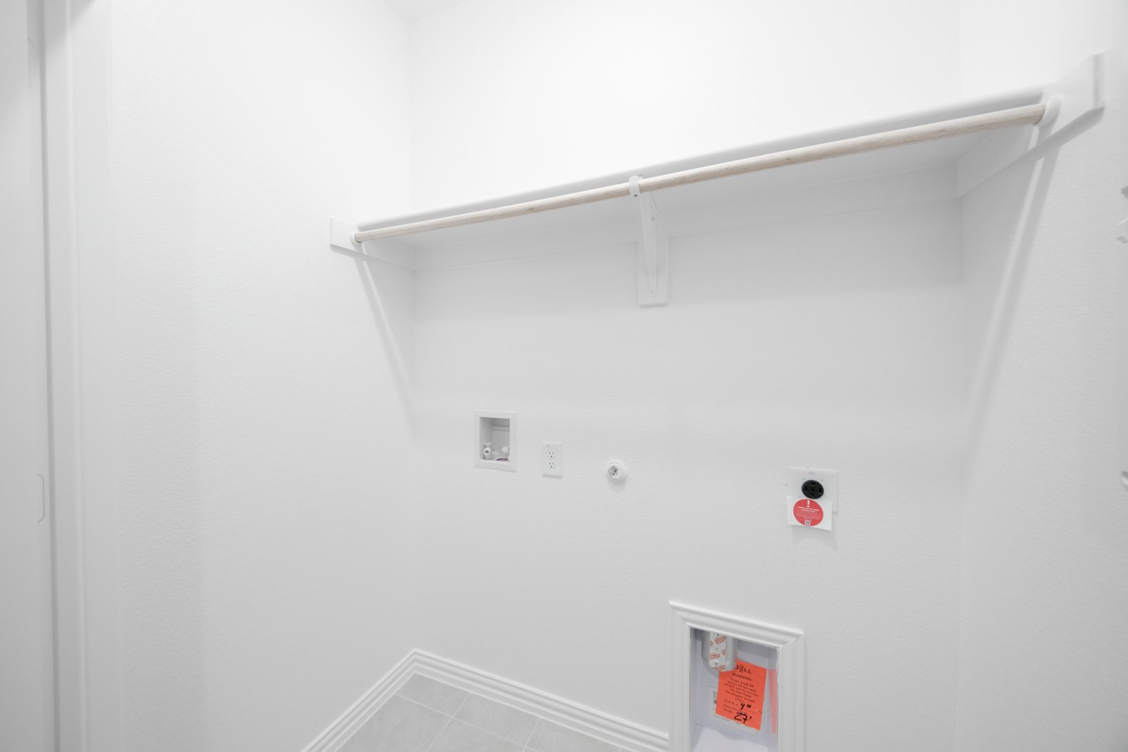 laundry room with tile floors and white shelf