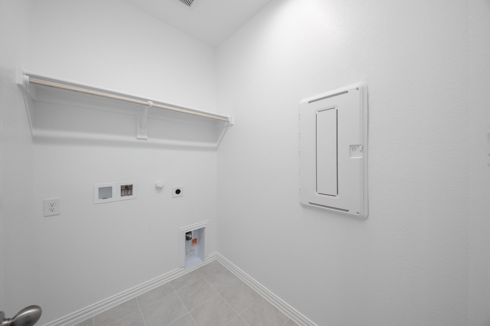 laundry room with tile floors and white shelf